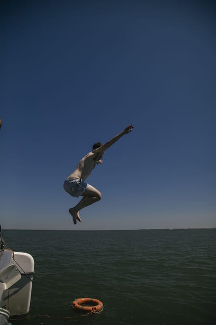 Lisbon: Catamaran Boat Party with Music, Open Bar & Dives - Swimming from the ladder: the cooling-off part you’ll actually use